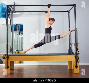 Pilates aerobics instructor woman in fitness exercise on cadillac