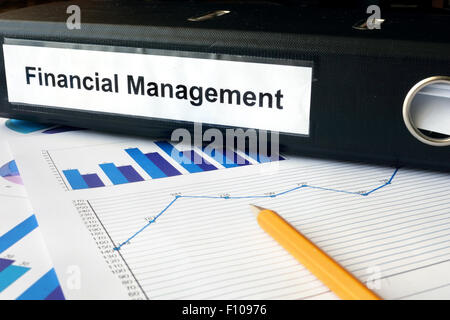Graphs and file folder with label Financial Management. Business concept. Stock Photo
