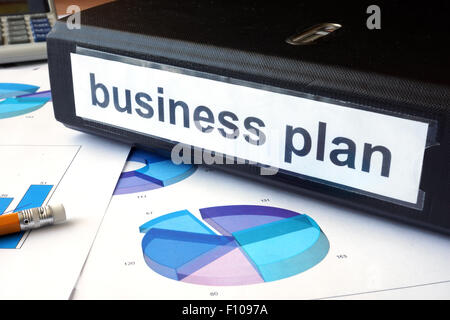 Graphs and file folder with label  Business plan. Stock Photo