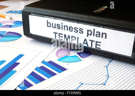 Graphs and file folder with label Business plan template. Stock Photo