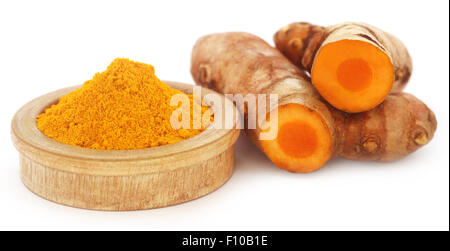 Ground and raw turmeric over white background Stock Photo