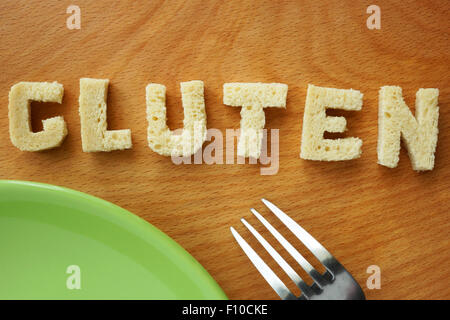 Word gluten from bread on a wooden board. Stock Photo