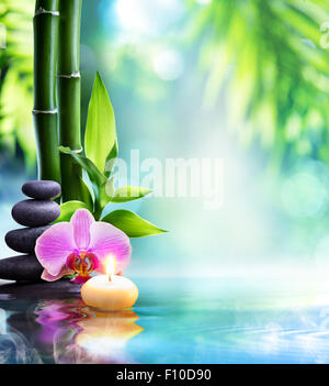 spa still life - candle and stone with bamboo in nature on water Stock Photo