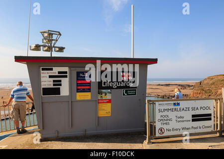 RNLI Lifeguard station overlooking Summerleaze sea pool and beach with sign. Bude, Cornwall, England, UK, Britain Stock Photo