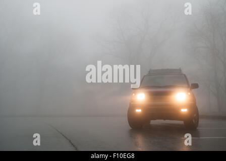 A red SUV sits in thick fog in a pullout along the Blue Ridge Parkway Stock Photo