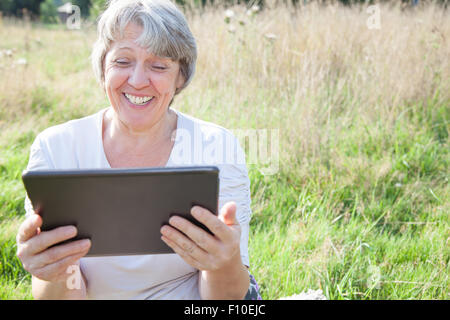 Old age woman using tablet device Stock Photo