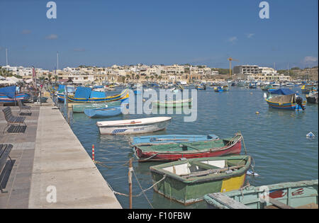 Colourful brightly painted traditional fishing boats in the harbour, fishing village of Marsaxlokk, Malta. Stock Photo