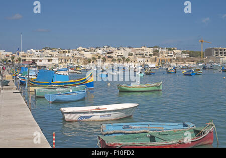 Colourful brightly painted traditional fishing boats in the harbour, fishing village of Marsaxlokk, Malta. Stock Photo
