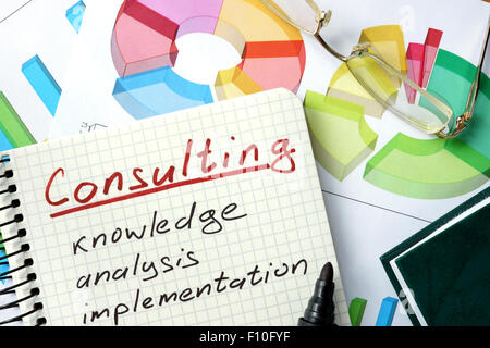 Consulting word written on the notepad and chart. Stock Photo