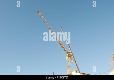 Silhouettes of construction cranes on the sky Stock Photo
