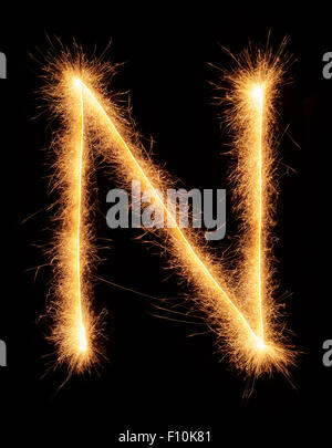 'N' letter drawn with bengali sparkles isolated on black background Stock Photo