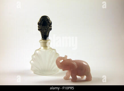 A vintage crystal perfume bottle and pink elephant Stock Photo