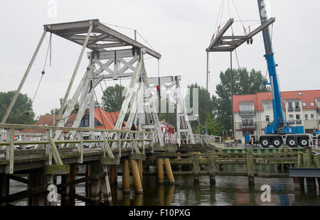 Greifswald-Wieck, Germany. 24th Aug, 2015. A balance beam of the broken bridge 'Klappbruecke' is dismantled by experts in Greifswald-Wieck, Germany, 24 August 2015. Several parts of the 128 year-old wooden bridge need to be rebuild due to fungal infestation. PHOTO: STEFAN SAUER/dpa/Alamy Live News Stock Photo