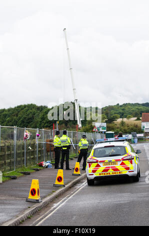 Shoreham-by-Sea, UK. 24th August 2015. The scenes in Shoreham-by-Sea, West Sussex, where a Hawker Hunter jet crashed into vehicles on the A27 and exploded during the Shoreham Air Show on Saturday 22nd August 2015. A crane has been brought to the site to remove the remains of the jet for further investigation. Many people have left floral tributes and football memorabilia on the Old Shoreham Tollbridge, close to the scene of the accident, for those that have died. Police say up to 20 people may have died in the incident. Credit:  Francesca Moore/Alamy Live News Stock Photo