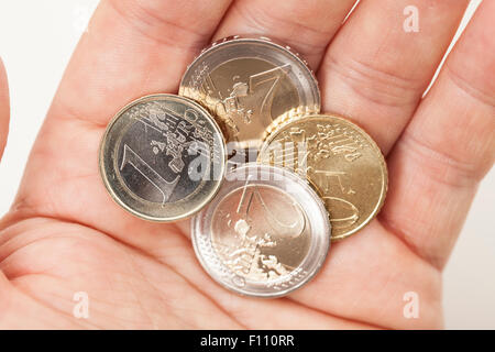 Various Euro coins in hand Stock Photo