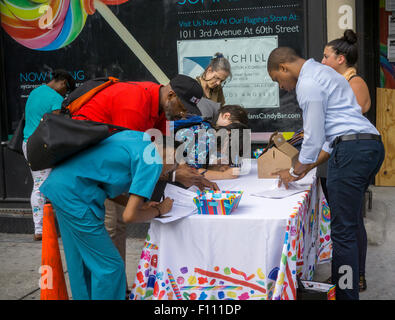 Prospective employees for Dylan's Candy Bar' s Union Square store fill out applications in front of the soon-to-be-opened store in New York on Thursday, August 20, 2015. Founded by Dylan Lauren, Dylan's Candy Bar sells over 7500 confections including their own private label and nostalgic candies in its 11 locations and online. (© Richard B. Levine) Stock Photo