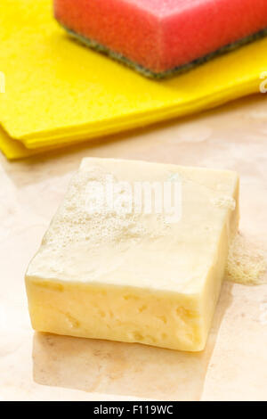 Bar of soap, duster and sponge on tile Stock Photo