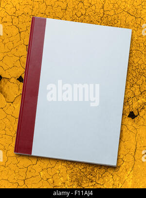Blank paper notebook on cracked yellow background Stock Photo