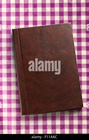 Blank closed notebook on checked lila background Stock Photo