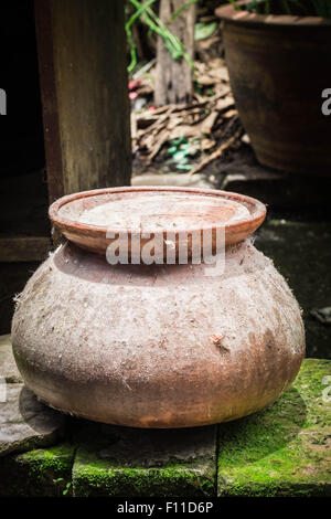 The old clay pot left on the brick floor. Stock Photo