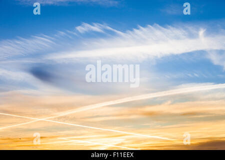 Geo engineering through airplane chemtrails sprayed in the sky, making it cloudy and polluting the environment. Stock Photo