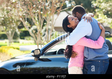 Couple hugging near convertible Stock Photo