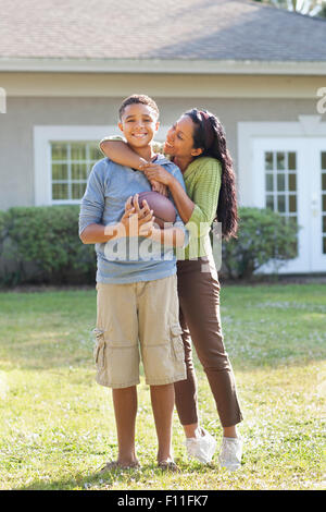 Mother and son hugging in backyard Stock Photo