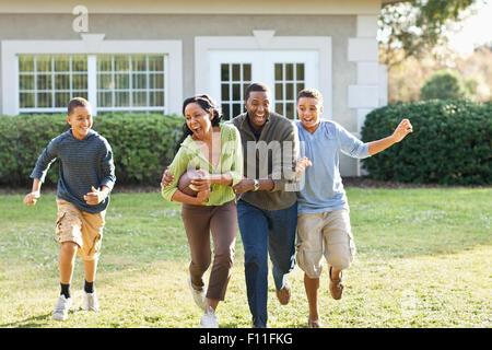 Family playing football in backyard Stock Photo