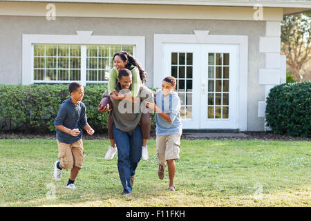 Family playing football in backyard Stock Photo