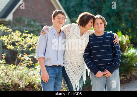 Caucasian mother and sons hugging outdoors Stock Photo