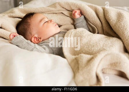 Mixed race baby sleeping in bed Stock Photo