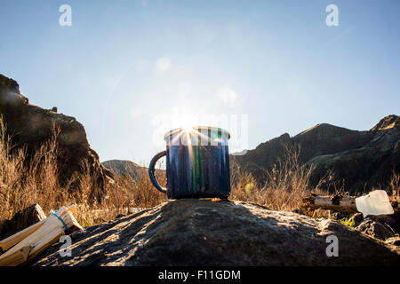 Close up of camping mug under remote mountains Stock Photo