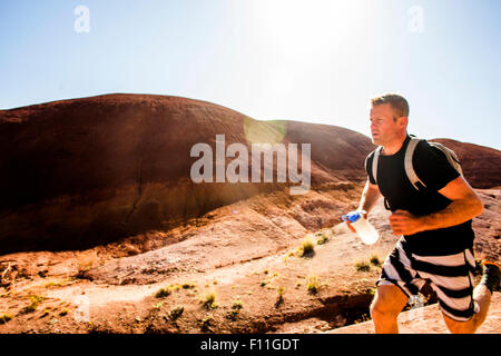 Caucasian man running in desert hills Stock Photo