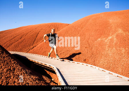 Caucasian man running on walkway in desert hills Stock Photo