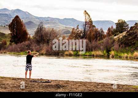 Caucasian man fishing in remote river, Painted Hills, Oregon, United States Stock Photo