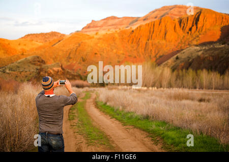 Caucasian man photographing desert hills, Painted Hills, Oregon, United States Stock Photo