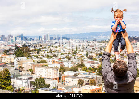 Caucasian father lifting daughter over San Francisco cityscape, California, United States Stock Photo