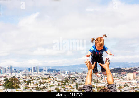 Caucasian father tossing daughter over San Francisco cityscape, California, United States Stock Photo