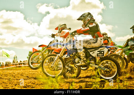 Caucasian motocross bikers riding on race course Stock Photo