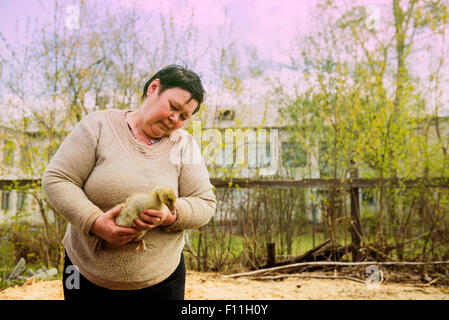 Caucasian farmer holding duckling on farm Stock Photo