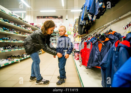 Caucasian mother and son shopping in clothing store Stock Photo