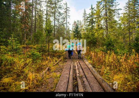 Caucasian hikers walking on forest path Stock Photo