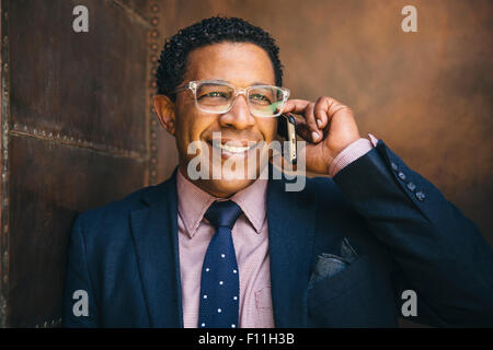 Mixed race businessman talking on cell phone Stock Photo