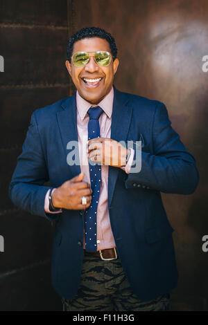 Mixed race businessman adjusting his tie