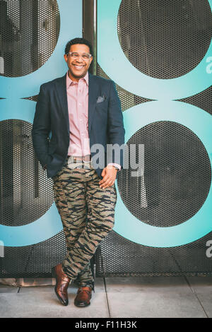 Stylish Mixed race businessman smiling outdoors Stock Photo