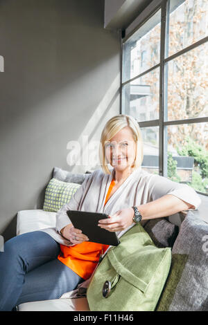 Caucasian businesswoman using digital tablet in office lobby