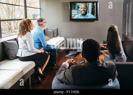 Business people watching teleconference in office meeting Stock Photo