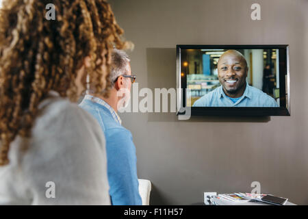 Business people watching teleconference in office meeting Stock Photo