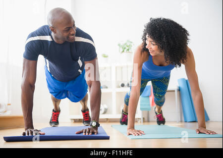 Couple doing push-ups in gym Stock Photo