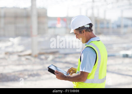 Caucasian architect using digital tablet at construction site Stock Photo